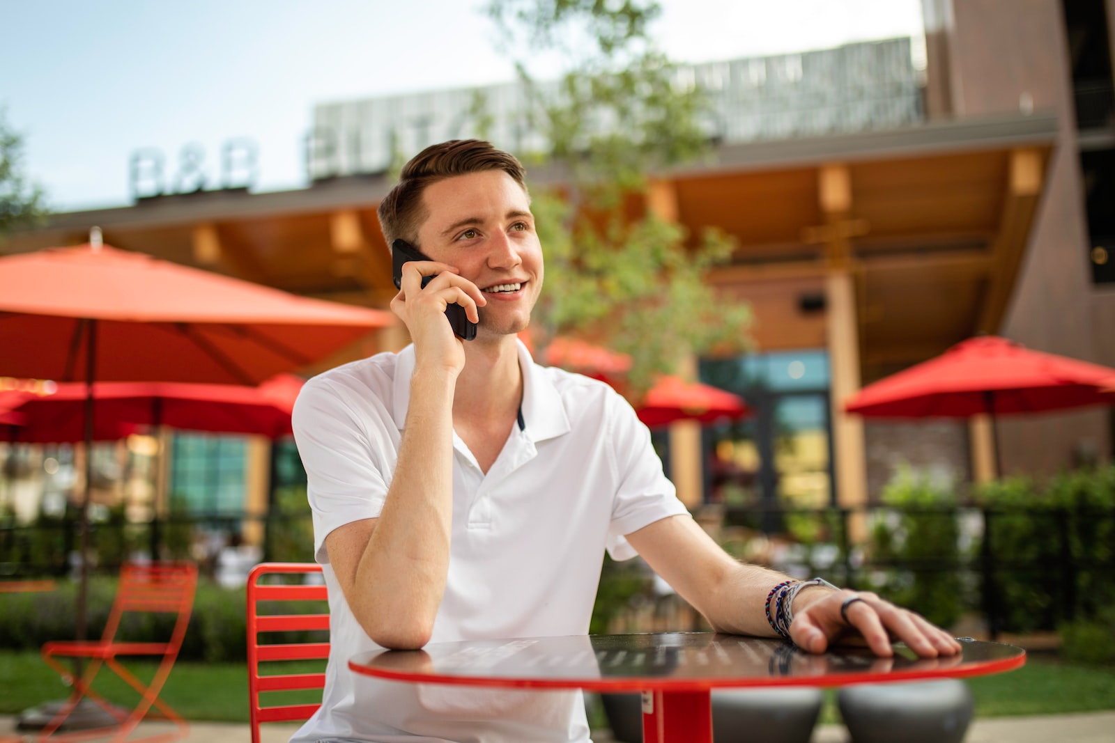 man in white crew neck t-shirt sitting on red bench